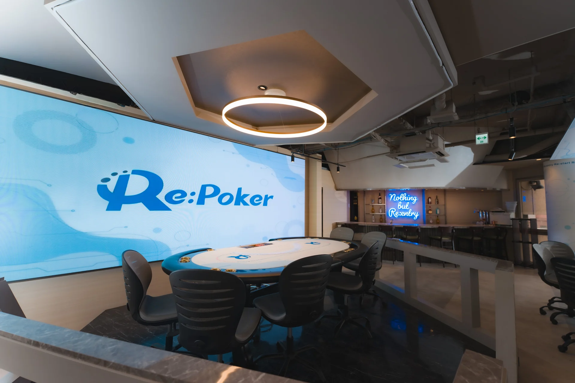 Re:Pokerの大型LEDサインとメインテーブルを望む店内